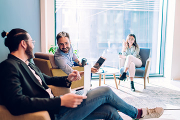 Cheerful coworkers communicating in bright lounge