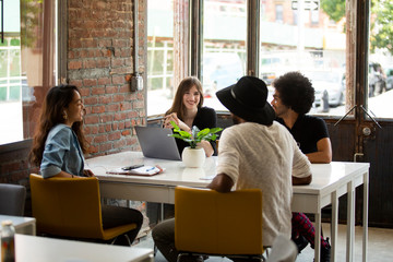 Fototapeta premium Multi-ethnic executives discussing at desk in coworking space