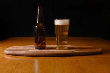 Isolated fresh beer on wooden table with bottle