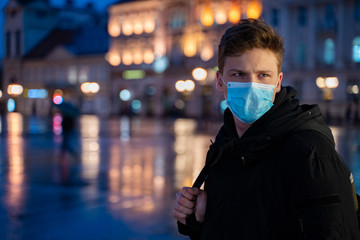Teenager alone in the city with surgical mask on face 