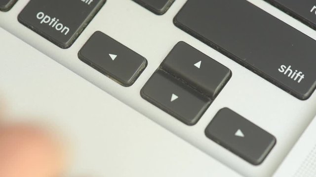 Fingers playing with the arrow keys on the laptop keyboard.