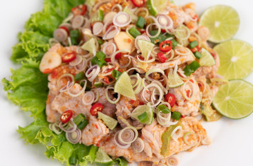 Spicy pork salad with galangal, lemon, chilli, garlic and put in a salad on a white plate.