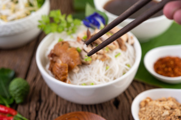 Chicken noodle in a bowl with side dishes, Thai food