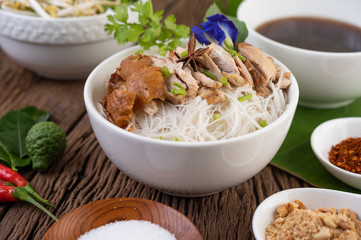 Chicken noodle in a bowl with side dishes, Thai food