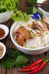 Chicken noodle in a bowl with side dishes, Thai food