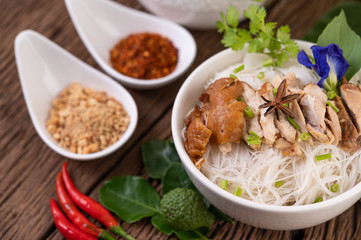 Chicken noodle in a bowl with side dishes, Thai food