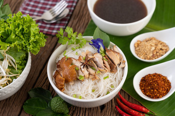 Chicken noodle in a bowl with side dishes, Thai food