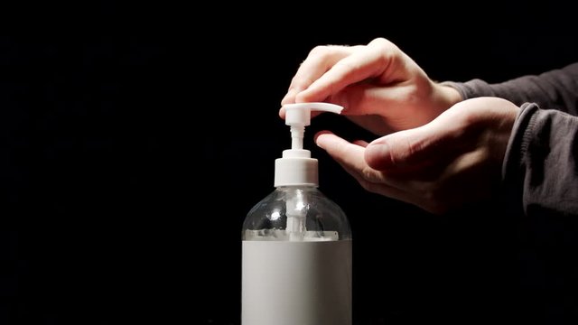 Male uses disinfection liquid to sanitize hands 