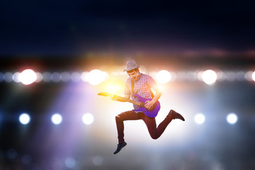 Fototapeta na wymiar Passionate guitarist with hat jumps
