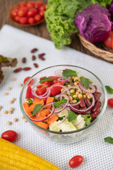 Fruit and vegetable salad in a glass cup on a white ground