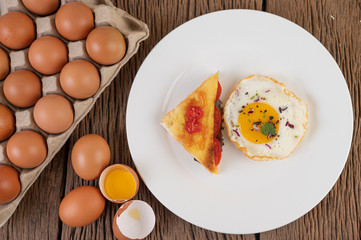 Fried egg on a white plate with toast, sliced ​​Spring onion and sliced ​​tomatoes