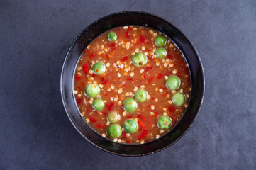 Shrimp-paste sauce in a black bowl on floor cement