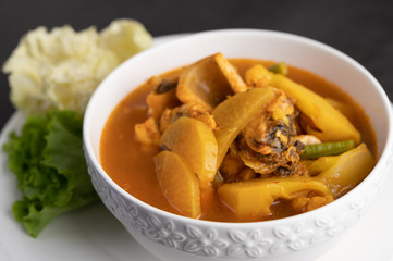 Yellow curry with snakehead fish, Thai food in a bowl on a plate.