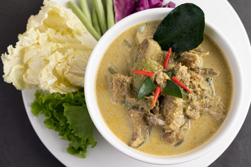 Chicken green curry in a white cup on the cement ground
