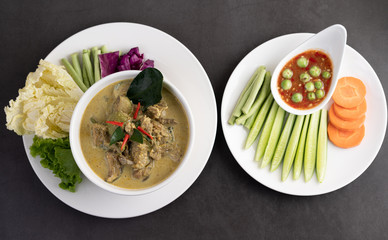 Chicken green curry in a white cup on the cement ground