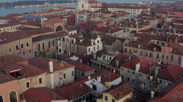 Aerial, tilt, drone shot over buildings and architecture, on a evening, in Venice, Italy