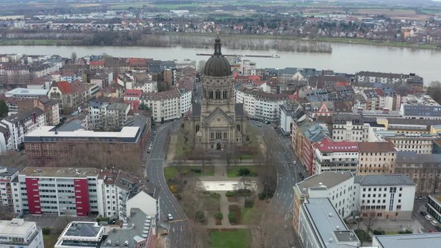 Aerial panorama fly away cinematic shot of the christus church in mainz with the river rhine in the background 30p