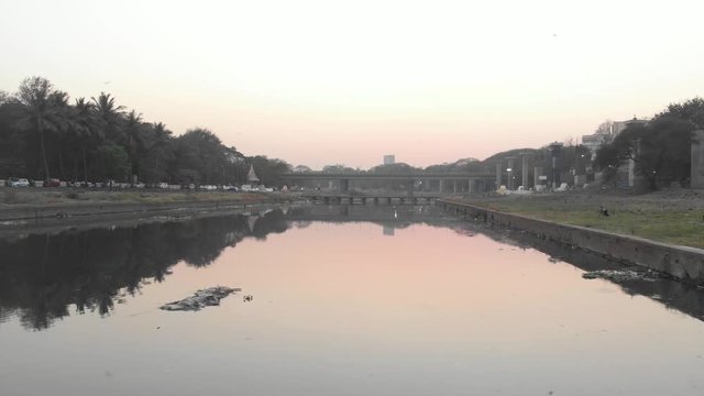 Drone shot still water reflection of a road bridge