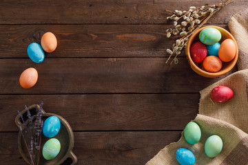 Still life many colorful easter eggs on a wooden background. Rustic. Decoration from natural fabrics and herbs. Easter celebration concept. Flat lay
