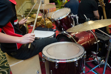 Fototapeta na wymiar Unidentified Asian boy play drum set in music room