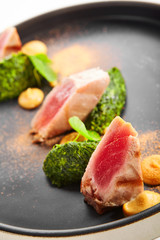Tuna fillet with stewed spinach close up view