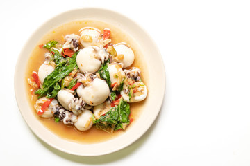 Stir fried Cuttlefish or Cuttlefish Rainbow with basil on plate isolated on white background with copy space; top view. Thailand's popular dishes (Pad Ga Pow).