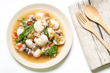 Stir fried Cuttlefish or Cuttlefish Rainbow with basil on plate with wooden spoon and fork; top view. Thailand's popular dishes (Pad Ga Pow).