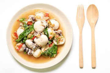 Stir fried Cuttlefish or Cuttlefish Rainbow with basil on plate with wooden spoon and fork; top view. Thailand's popular dishes (Pad Ga Pow).