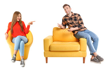 Happy couple discussing something while sitting in armchairs against white background
