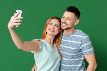 Couple taking selfie on color background