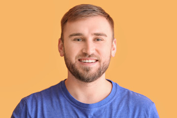 Obraz premium Happy smiling young man with healthy teeth on color background