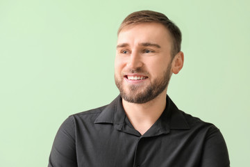 Obraz premium Happy smiling young man with healthy teeth on color background
