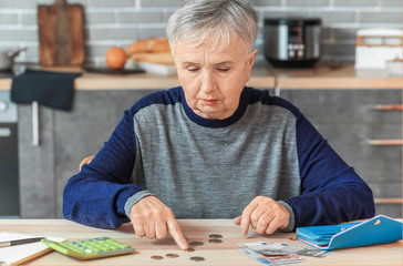 Senior woman counting money at home