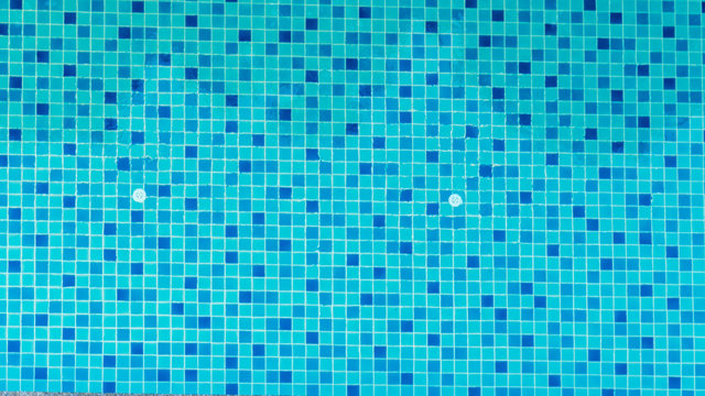 Swimming Pool Bottom Is Source Tiles And Water Waves Background. Summer Texture Of Water Surface Overhead View.