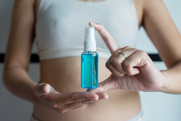 Obraz na płótnie Canvas Woman hands holding sanitizer gel in spray bottle for hand hygiene coronavirus protection