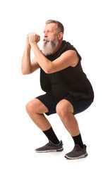 Sporty elderly man training on white background