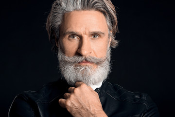 Stylish elderly man on dark background