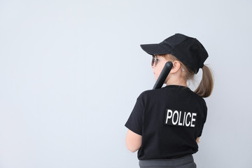 Cute little police officer on light background