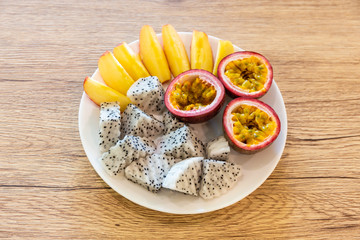 Passion fruit, dragon fruit, sliced apples and beautifully arranged in a ready-to-eat rice dish on a wooden table