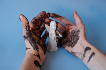 Man holds the figure of an angel in his hands