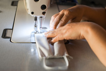 Handmade mask sewing from the fabric is used to prevent disease outbreaks with dust and viruses close-up.