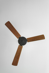 Bottom view of wooden fan hanging from the ceiling in bedroom