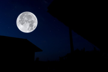 Full moon at night with silhouette house.