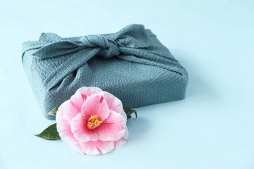 ピンクの椿の花と風呂敷包み