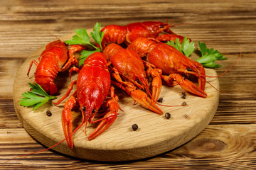Boiled crayfish on cutting board on wooden table