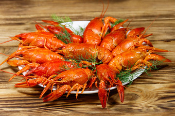 Boiled crayfish in plate on wooden table