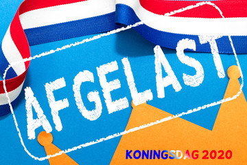 Fototapeta na wymiar Dutch word afgelast (canceled) over an orange paper crown and red white and blue ribbon for King's day