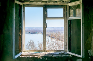 view of the river and the village from an old open window of an abandoned house on the top of a mountain