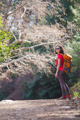 Obraz premium A girl with a backpack goes along a mountain trail.