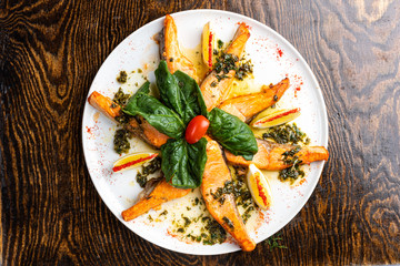 baked salmon on a white plate with slices with salad and spices